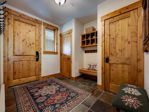Step into your private mountain retreat through this welcoming entryway, where rustic knotty pine doors and custom storage await your arrival after a day exploring the slopes.