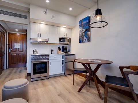 Your stylish open-concept suite features a fully equipped kitchen with stainless appliances, cozy dining nook, and modern air-conditioned comfort for relaxing mountain getaways.