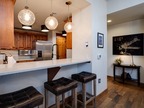 Pull up a seat at your private breakfast bar, where elegant pendant lights and sleek appliances make every meal feel special in your well-appointed kitchen.
