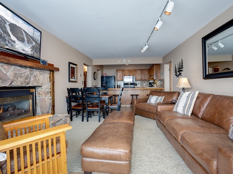 Relax in your open-concept retreat with a cozy stone fireplace, spacious leather seating, and a fully equipped kitchen—perfect for unwinding after your mountain adventures.