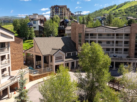 The Chateau Chamonix nestles in a picturesque mountain village, surrounded by lush hillsides and alpine architecture, offering a serene arrival experience.