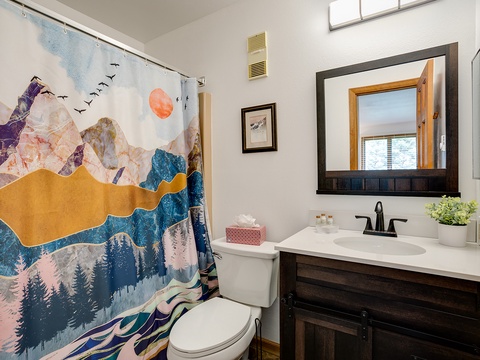Step into your private bathroom with artistic mountain-inspired shower curtain and modern vanity. Fresh linens and thoughtful touches create a bright, welcoming space where you can refresh after a day of adventure.