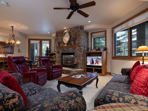 Sink into plush seating by the stone fireplace, where you can unwind after your mountain adventures with your favorite shows and cozy warmth.