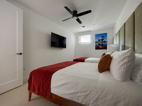 Drift off in crisp linens beneath the gentle whir of your ceiling fan, with natural light filtering through the window and a cozy accent to welcome you home.