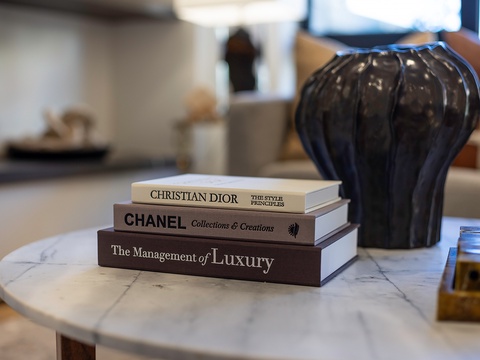Curated coffee table books rest beside a sculptural vase, adding a sophisticated touch to your living space with elegant details and refined style.