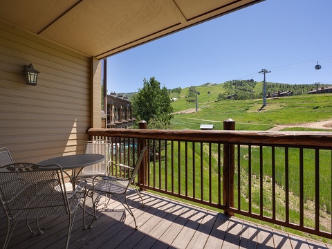 The property is located near mountain slopes with ski lift infrastructure visible in the surrounding landscape, offering scenic green hillside views during the warmer months.