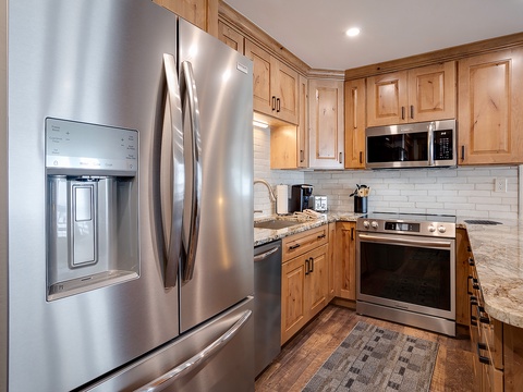 Cook up your favorite meals in this spacious kitchen equipped with modern stainless steel appliances, elegant wood cabinetry, and granite countertops—everything you need for a relaxing mountain getaway.