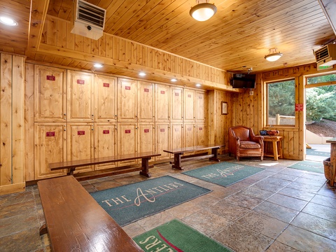 Warm wood-paneled entry greets you with organized locker storage and a cozy reading nook, blending rustic charm with practical amenities for your stay.