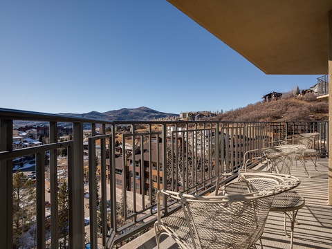 A private balcony overlooking mountain ranges and the surrounding neighborhood, offering fresh air and scenic views from the property.