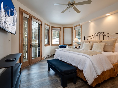 Wake up to stunning winter views through floor-to-ceiling windows. Your cozy bedroom features plush bedding, a private balcony, and peaceful mountain scenery just outside.