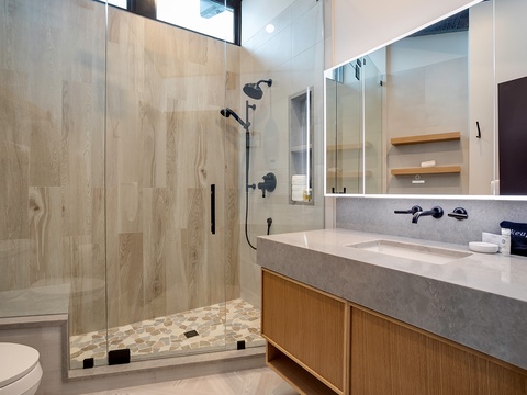 Refresh in your sleek modern bathroom, featuring a spacious walk-in shower, elegant stone countertop, and contemporary finishes that blend style with comfort.
