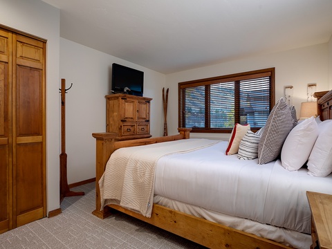 Unwind in your cozy bedroom with warm wood furnishings and plush linens, where you'll rest easy after a day of adventure with every comfort close at hand.