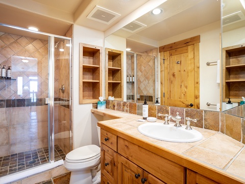 Relax in your private spa-inspired bathroom with custom tile work, spacious walk-in shower, and warm wood cabinetry that brings mountain-lodge comfort to your daily routine.