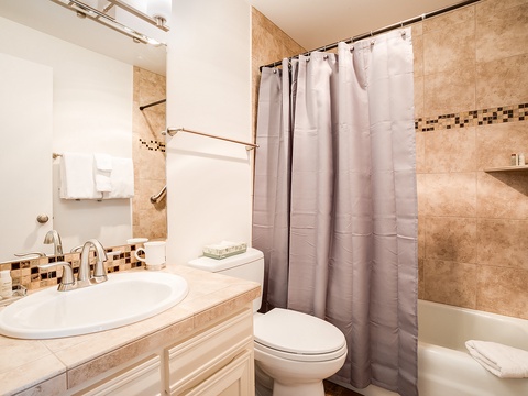 Step into your beautifully tiled bathroom, complete with elegant mosaic accents and fresh towels ready for your arrival. The spacious tub-shower combo offers the perfect retreat after a day of exploring.