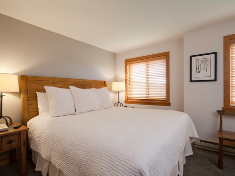 Step into your peaceful retreat with a plush bed calling you to sink in after a day of adventure. Warm wood tones and soft lighting create a cozy haven where your relaxation begins.