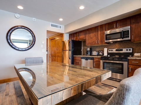 Step into your fully equipped kitchen with rich wood cabinetry, stainless appliances, and a stylish breakfast bar perfect for morning coffee or casual meals.