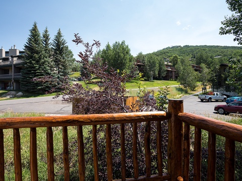 A vacation rental property nestled in a peaceful residential area, surrounded by lush evergreens and rolling hills, offering a serene mountain retreat setting.