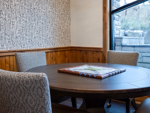 A quiet corner awaits your morning coffee or evening plans. Settle into the woven chairs at this round table, maps ready to guide your next adventure in the area.