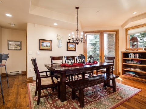 Gather around this handsome dining table with seating for everyone. Natural light floods the space through large windows, perfect for leisurely meals and conversation.