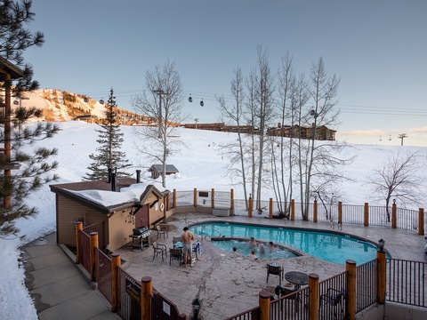 Snow-covered slopes frame the outdoor pool area, where winter relaxation meets mountain adventure at this ski-in property with scenic alpine views.