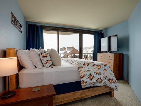 Your cozy retreat features crisp linens, calming blue walls, and a private balcony with scenic views—perfect for unwinding after a day of exploring.
