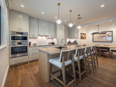 Gather with your group in this beautiful open kitchen and dining space, where sleek countertops and modern appliances make meal prep a breeze while everyone stays connected.