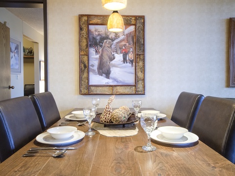 Gather around this inviting dining table for memorable meals with your group. The warm wood tones and comfortable seating create the perfect spot for sharing stories and laughter together.