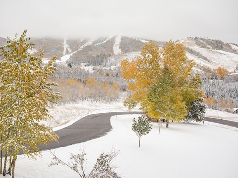 Snow-dusted ski slopes meet autumn's golden foliage, showcasing the property's stunning mountain resort location where seasonal transitions create breathtaking natural beauty.