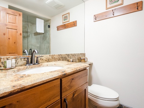 Freshen up in your private bathroom with granite countertops, a glass-enclosed shower, and rustic wood accents that bring warmth and charm to your space.
