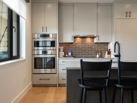 Step into your sleek modern kitchen with custom cabinetry, stainless appliances, and a cozy breakfast bar where you can sip coffee and plan your day.
