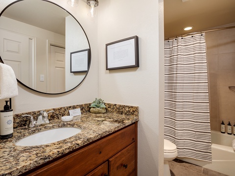 Step into your private bathroom, where a stylish round mirror, granite vanity, and fresh towels await. The tub-shower combo offers a relaxing retreat after your adventures.