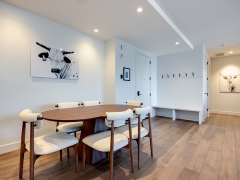 Gather around the elegant oval dining table where shared meals and memories come naturally. Light wood floors and crisp white walls create a bright, welcoming space for your group to connect.