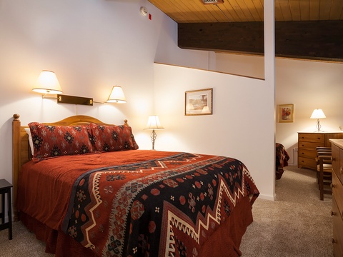 Sink into your cozy bed beneath warm lighting, surrounded by Southwestern-style comfort and wood-beam accents that make this your perfect mountain retreat.