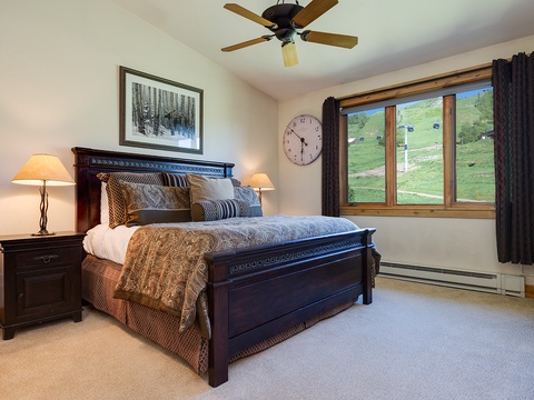 Drift off in your cozy bedroom, where mountain views frame your peaceful retreat. Soft lighting and rich wood furnishings create a warm, inviting space for restful nights.
