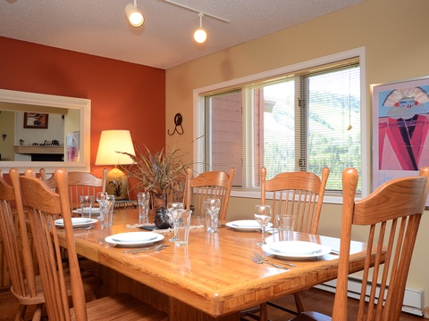 Gather around this warm dining space, where natural light and colorful artwork set the stage for memorable meals with loved ones during your stay.