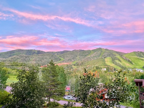 Stunning mountain vistas under pastel sunset skies define the scenic landscape surrounding this property, offering guests a tranquil retreat in a picturesque natural setting.