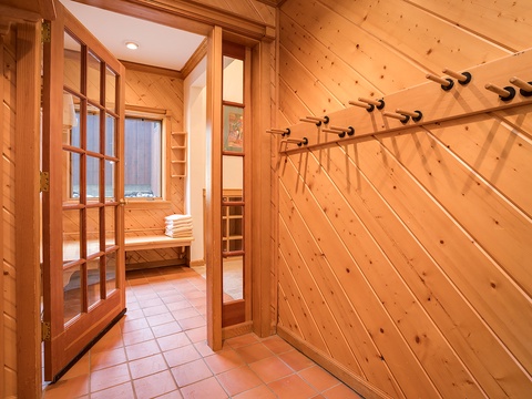 Warm wooden walls and natural light create a serene entry to your private sauna retreat, where fresh towels await your relaxation.