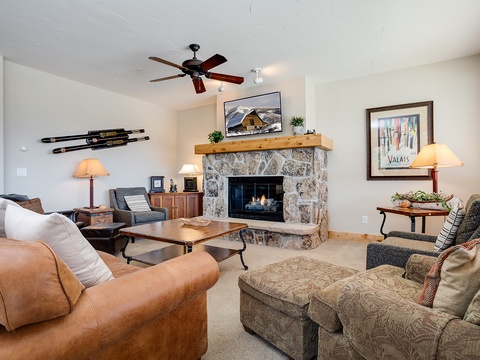 Curl up in your inviting living room where a glowing stone fireplace and mountain-inspired decor create the perfect alpine retreat after a day of adventure.