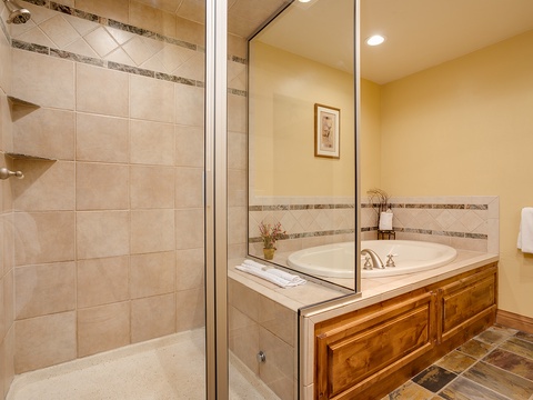 Unwind after a day of adventures in your spacious bathroom, featuring a tiled walk-in shower and a soaking tub perfect for total relaxation.