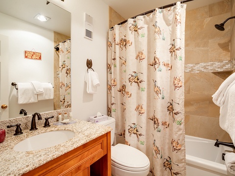 Freshen up in your welcoming bathroom with warm tones, plush towels, and playful western-themed accents that add charm to your stay.