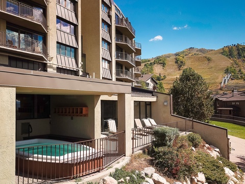 Multi-level building nestled in a mountain valley, offering easy access to alpine slopes and scenic hillside views from private balconies.