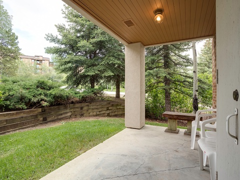 Unwind on the covered patio overlooking mature pines and landscaped gardens. Perfect for morning coffee or evening relaxation with serene greenery all around.