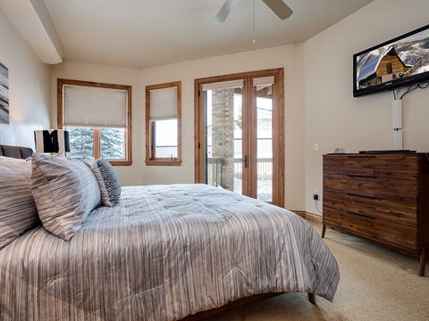 Sink into this cozy bedroom where soft linens and mountain views await. Step onto your private balcony and breathe in the crisp alpine air as sunlight streams through wood-framed windows.