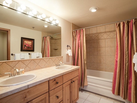 Freshen up in your spacious bathroom with dual sinks, a soaking tub, and warm lighting that makes mornings feel a little brighter and evenings extra relaxing.