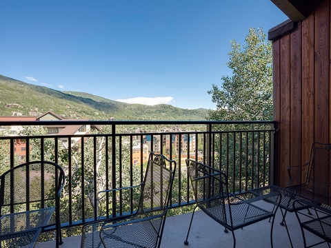 A private balcony overlooking lush mountains and surrounding area offers a perfect spot to enjoy morning coffee or evening relaxation in the crisp mountain air.