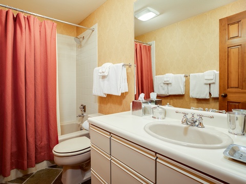 Your private bathroom offers a tub-shower combo, fresh towels, and a spacious vanity—everything you need to feel refreshed after a day of adventure.