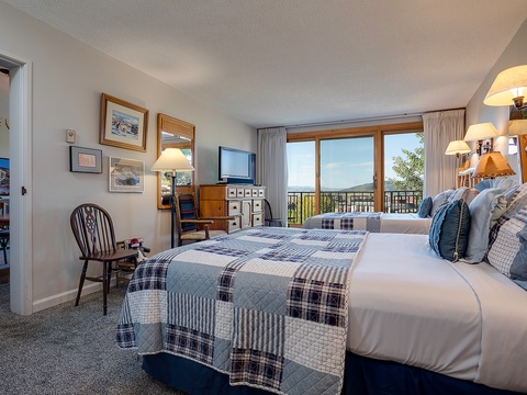 Sink into plush linens and wake to breathtaking mountain vistas framing your private balcony. Your cozy retreat blends rustic charm with modern comforts for the perfect escape.