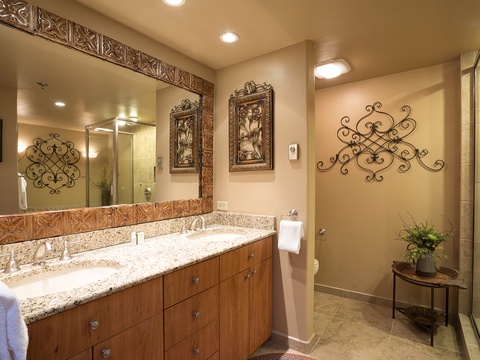 Your spacious bathroom features dual vanities with granite countertops, a walk-in shower, and elegant decor—designed for comfort and relaxation after a day of adventure.
