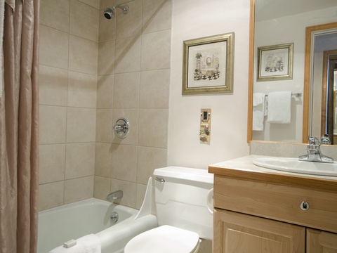 Your private bathroom features a classic tub-shower combo, single vanity with mirror, and thoughtful touches like framed art to make you feel right at home.