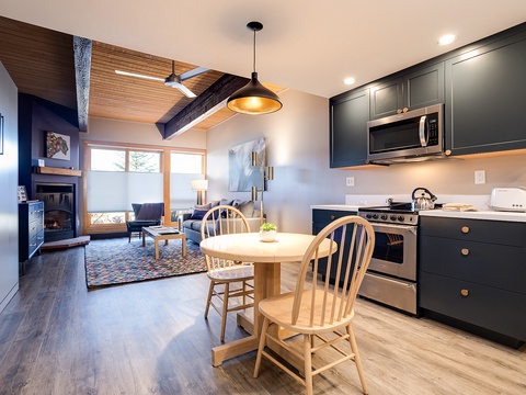 Your stylish retreat awaits with vaulted wood ceilings, a cozy fireplace, and a fully equipped kitchen where you can whip up meals before relaxing in the inviting living space.